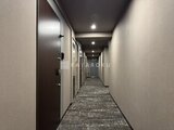 アーバネックス両国レジデンス 落ち着いた色合いでまとめた廊下から各戸への入口が並ぶ共用部