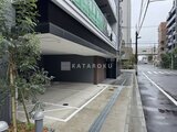 アーバネックス両国レジデンス 街路沿いに開放感のあるエントランスと駐車場入口がある建物外観