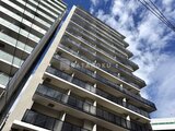 クレストコート王子 青空を背景に映るモダンな外観の建物