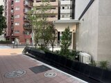 クレストコート王子 赤レンガの建物に隣接した、モダンなエントランスと共用庭の様子