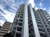 クレストコート王子 青空を背景に撮影した、落ち着いた印象の建物外観
