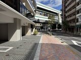 クレストコート王子 建物前の広場から見た、モダンなデザインの外観と周辺の街並み