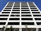 ザ・パークハビオ白金高輪 青空を背景に、白と黒のコントラストが際立つモダンな建物外観