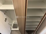 ザ・パークハビオ白金高輪 木目調の扉と白い棚板が組み合わされたクローゼット内部
