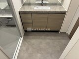 ザ・パークハビオ白金高輪 グレーの落ち着いた洗面台と広めの洗面脱衣室の様子