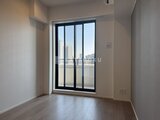 ザ・パークハビオ白金高輪 大きなバルコニー窓から都市風景を望む明るい洋室