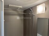 ラティエラ武蔵小山レジデンス モダンな色合いの浴室にシャワーヘッドと小窓がある様子
