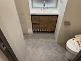 ラティエラ武蔵小山レジデンス 洗面台と木製収納が備わった落ち着いたトイレ空間