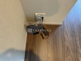 ラティエラ武蔵小山レジデンス ウッド調フローリングの玄関と白壁に設置されたコンセント