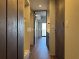 ラティエラ武蔵小山レジデンス 温かみのあるクロス壁と木調フロアが落ち着いた雰囲気の廊下