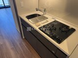 ラティエラ武蔵小山レジデンス ガスコンロと白い天板のシンクを備えたコンパクトなキッチン