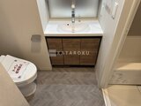 ラティエラ武蔵小山レジデンス 木目調の洗面台と白いトイレが並ぶコンパクトな水回り空間