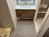 ラティエラ武蔵小山レジデンス 木目調の洗面化粧台と落ち着いた配色のタイル床の洗面室