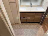 ラティエラ武蔵小山レジデンス 木目調のバニティキャビネットと白い洗面ボウルが置かれた洗面室