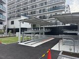 リビオメゾン東陽町ヒュッテ 白いカーポートと駐輪場を備えた開放的な共用駐車スペース