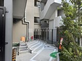 ヴィラクレール巣鴨 建物後部の駐輪スペースと緑が調和した外観