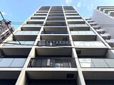ヴィラクレール巣鴨 青空を背景に捉えたモダンな中層マンションの建物正面