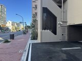 パークアクシス大森山王 前面道路から見た建物のエントランスと駐車場入口の様子