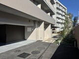 パークアクシス大森山王 明るい日差しが差し込むモダンな駐車場とエントランスの様子