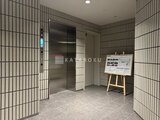 パークアクシス大森山王 エレベーターと案内板が備わった落ち着いた印象の共用玄関