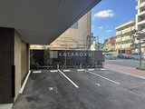 パークアクシス大森山王 駐車場から見た建物と緑の目隠しフェンス