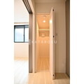 ヴィスタ中野坂上 明るい採光が入る廊下から見た開き戸のトイレ入口