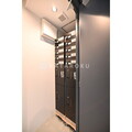 ヴィスタ中野坂上 建物エントランスの宅配ボックスと郵便受けが設置された壁面