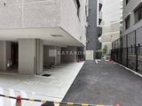 テラス神田猿楽町 建物エントランスと駐車場が広がるモダンな外構の様子