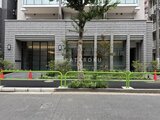 テラス神田猿楽町 前面道路から見たモダンな建物外観と緑化スペース