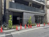 アーバネックス日本橋水天宮前 深色タイルの外観にエントランスと植栽が調和した建物前面