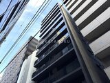 アーバネックス日本橋水天宮前 建物下層部から見上げた、モダンな外観と青空が映り込む様子