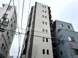 アーバネックス文京千駄木 立ち並ぶビルに囲まれた、モダンなデザインの建物外観