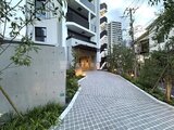 クレストコート東池袋 緑を配置した開放的なアプローチから見たモダンな建物外観