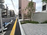 クレストコート東池袋 前面道路から見た建物外観と植栽のある開放的なエントランス空間
