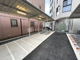 クレストコート東池袋 屋根付きの駐車場と建物を備えた敷地全体の様子