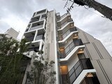 クレストコート東池袋 下から見上げた白を基調とした建物外観と手すり付きのバルコニー