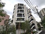 クレストコート東池袋 前面道路から見たモダンな印象の建物外観と植栽が調和する敷地
