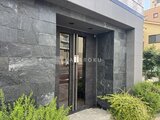 プレセダンヒルズ目黒柿の木坂 モダンな石張り仕上げのエントランスと植栽に囲まれたアプローチ