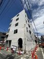 ブライト本所 白を基調とした現代的な建物の前面道路からの外観