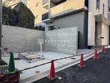 プレジリア代々木参宮橋 建設中の駐車スペースと囲いの壁が見える建物外観