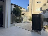 プレジリア代々木参宮橋 開放的な庭スペースと黒いフェンス門がある敷地外観