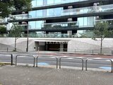 パークマンション檜町公園 駐車場入口と植栽が配置された建物の低層部外観