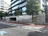 パークマンション檜町公園 前面道路から見たモダンな建物外観と緑に囲まれた入口の様子