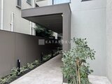 アトリオフラッツ自由が丘イースト モダンな庇を備えたエントランスアプローチ、植栽が潤いを添える
