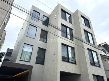 アトリオフラッツ自由が丘イースト 白いタイル張りのモダンな建物外観と駐車スペース