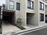 アトリオフラッツ自由が丘イースト 白を基調とした建物の開放的なエントランスと駐車スペース