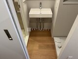 アトリオフラッツ自由が丘イースト 木目調フローリング張りの洗面室と洗面台の全景