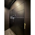 アジールコート下高井戸 モダンな黒い外壁が印象的な建物のエントランス