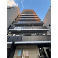 アーバネックス菊川4 下から見上げた建物外観、青空を背景にした立面図