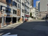 デュオメゾン西新宿 前面道路から見た建物外観と周辺の街並み